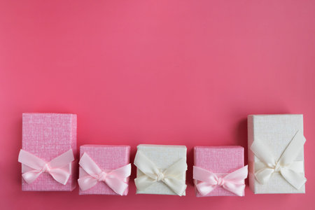 Boxes for small presents and gifts in pastel colors on a pink background with space for text....