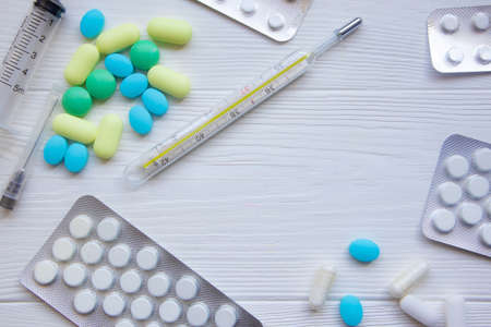 Thermometer, syringe and pills on a white background with space for text. Template.の写真素材