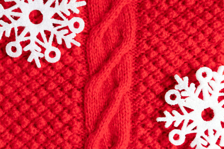 Warm red Christmas sweater with snowflakes as a background, close-up. Layout template.