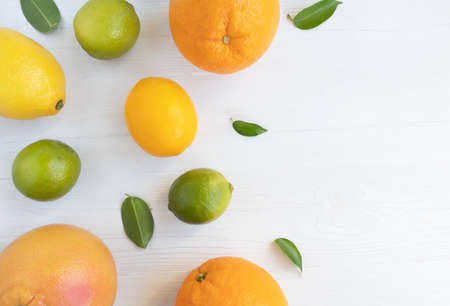 Lemons, lime, orange and whole grapefruit on a white background with space for text. Poster, banner.の写真素材