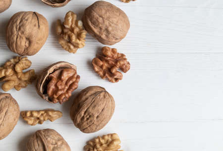Walnut whole and peeled on a white wooden background with space for text. Article.の写真素材