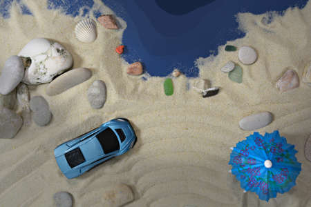 Blue car on a sandy beach near the sea.の写真素材