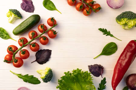 Vegetables for salad on a white wooden background with place for text. Layout for poster, menu.の写真素材