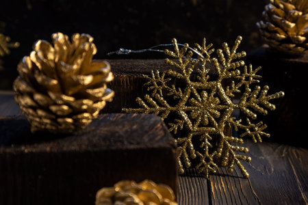 Gold snowflake and fir cones on a dark background. Poster, banner.
