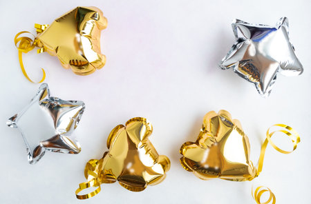 Three gold hearts and stars foil balloons, top view on a white background. Valentines day, postcard, banner.の写真素材