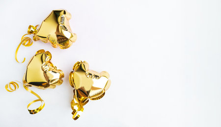Three gold hearts, foil balloons top view on white background. Valentines day, banner, postcard.の写真素材