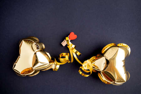 Gold balloons in the shape of a heart on a dark background with space for text.の写真素材