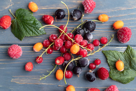 Frozen berries from the refrigerator on a wooden background. The concept of frozen food, long-term...