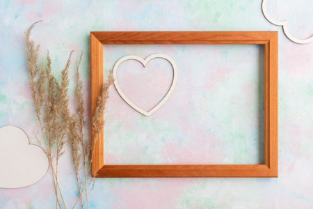 A frame with a heart and Pampas dry grass on a delicate background with space for text.の写真素材