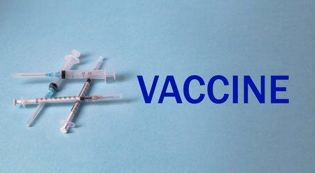 A hashtag sign laid out of syringes and the text vaccine. ...