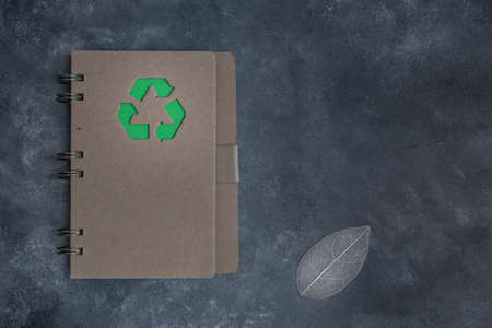 A paper notebook with a green eco-symbol on a gray background with space for text. Zero waste concept.の写真素材
