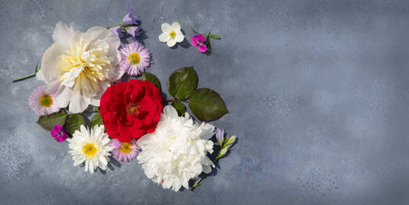 Flower arrangement on a gray background with space for text. Top view, flat layout. Postcard.