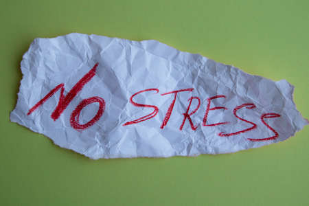 The concept of dealing with stress. A piece of paper with the text no stress on a green background.の写真素材
