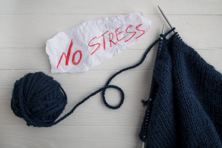 The concept of dealing with stress. Needlework, hobbies, knitting. White background and text .