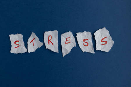 Scraps of paper with red letters on a blue background The concept of reducing, relieving and managing stress.の写真素材