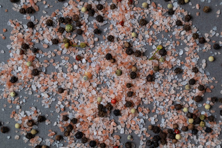 Background with pink salt crystals and different types of peppers. Pattern.