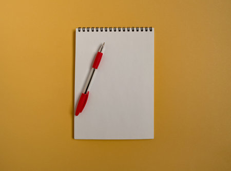 A clean white notepad page with a pen on a yellow background. Space for text.