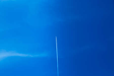 Flying airplane in clean blue skyの写真素材