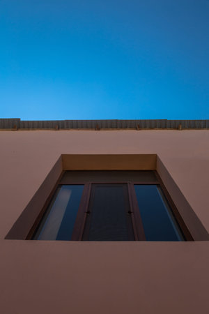 Blue sky and it's reflection on single window of the house