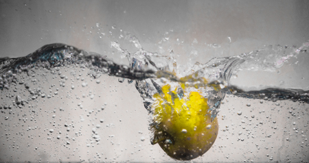 An Apple dip in aquarium with water splashesの写真素材