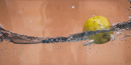An Apple dip in aquarium with water splashesの写真素材