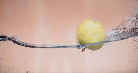 An Apple dip in aquarium with water splashesの写真素材