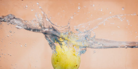 An Apple dip in aquarium with water splashesの写真素材