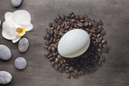 Coffee beans and Easter egg with Orchid on greyの写真素材