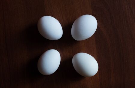 Four white Eggs on wooden table backgroundの写真素材