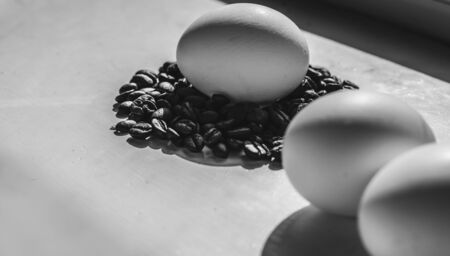 Coffee beans and Easter eggs, dyed with coffee on a background of burlap. Black and white style.の写真素材