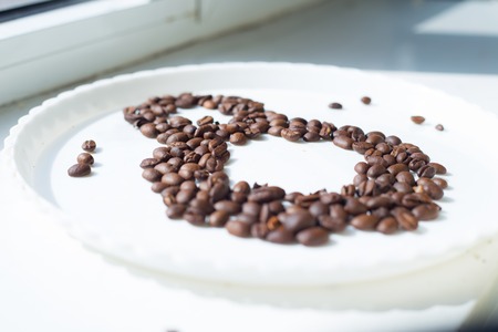 Coffee beans in form of number 8 and orchids on white plastic plate. International women's day. 8th marchの写真素材