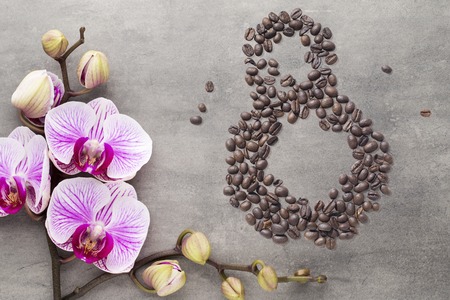Coffee beans in form of number 8 and orchids on beautifull background. International women's day. 8th marchの写真素材
