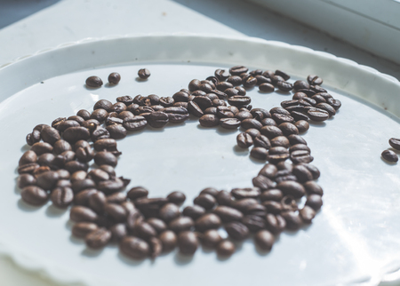 Coffee beans in form of number 8 and orchids on white plastic plate. International women's day. 8th marchの写真素材