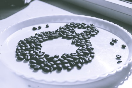Coffee beans in form of number 8 and orchids on white plastic plate. International women's day. 8th marchの写真素材