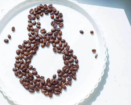 Coffee beans in form of number 8 and orchids on white plastic plate. International women's day. 8th marchの写真素材