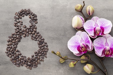 Coffee beans in form of number 8 and orchids on beautifull background. International women's day. 8th marchの写真素材