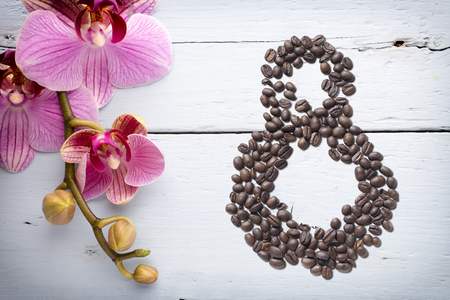 Coffee beans in form of number 8 and orchids on beautifull background. International women's day. 8th marchの写真素材