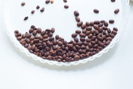 Coffee beans on a white plastic plate. beautifull background. Love. Insparation. On white plate. Romantic.の写真素材