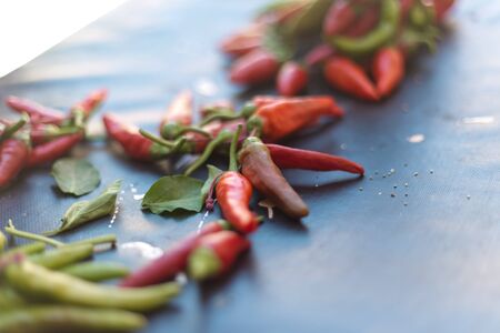 From above pile of red and green pepper placed on dark board background.の写真素材