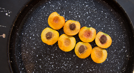 Background of peaches halves arranged in two rows on marble surface.の写真素材