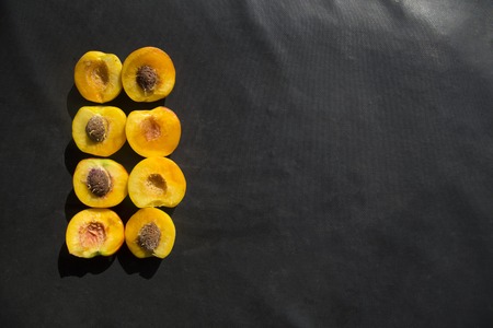 Background of peaches halves arranged in two rows on marble surface.の写真素材