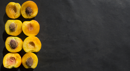 Background of peaches halves arranged in two rows on marble surface.の写真素材