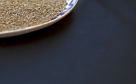 From above shot of ornamental plate filled with fresh aromatic cumin spice.の写真素材