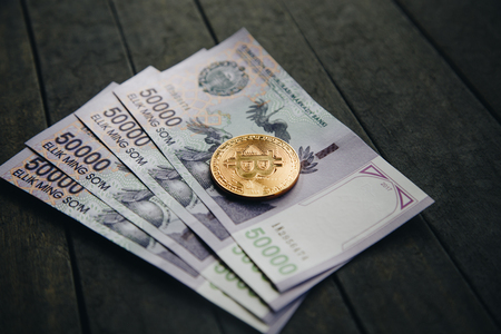 Uzbek banknotes and and Bitcoin on wooden background. Currency. Uzbek Money. Fifty Thousand Uzbek Sums 50000の写真素材