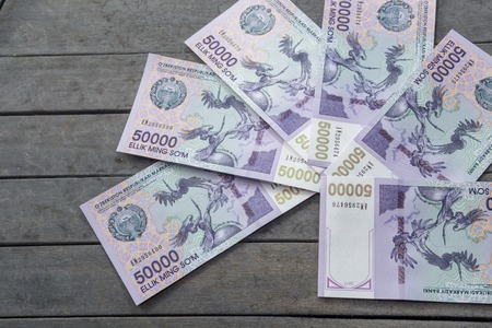 Uzbek banknotes on wooden background. Currency. Uzbek Money. Fifty Thousand Uzbek Sums 50000の写真素材