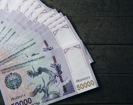 Uzbek banknotes on wooden background. Currency. Uzbek Money. Fifty Thousand Uzbek Sums 50000の写真素材