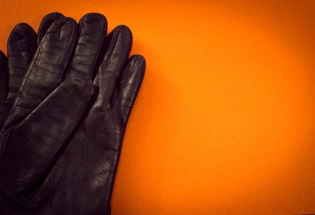 Two leather gloves from above on orange background.の写真素材