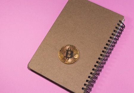 Flat Lay photo with Notebook and Cryptocurrency physical golden bitcoin coin.の写真素材