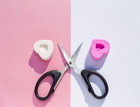 Sugar sweets on different sides and scissors, as a symbol of separation of lovers on divided backgroundの写真素材