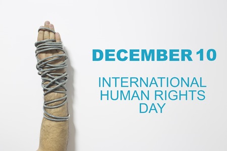 Human rights concept: chained man against the text: Human rights day written with chalk on blackboard.の写真素材